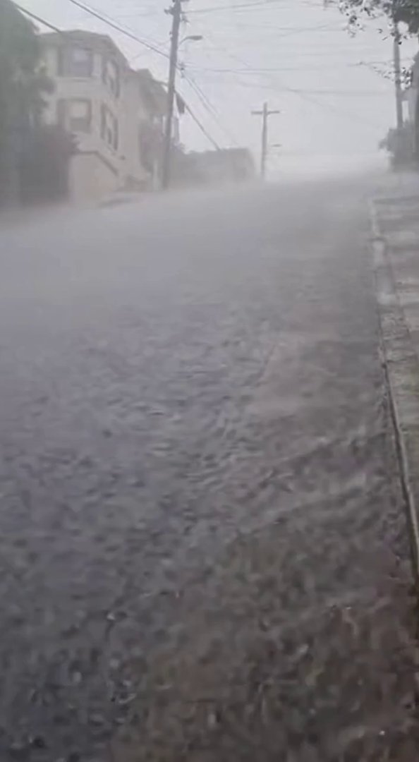 [Sora 2] {
  "scene_overview": "Steep downhill street during heavy rain. Water streams down the asphalt. Hou... - Veo 3 AI video prompt thumbnail