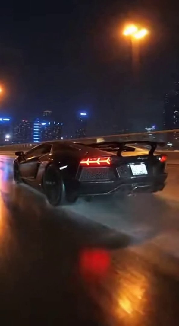[Sora 2] Ultra-photorealistic night highway scene. A black Lamborghini Aventador speeds on a wet road under c... - Veo 3 AI video prompt thumbnail