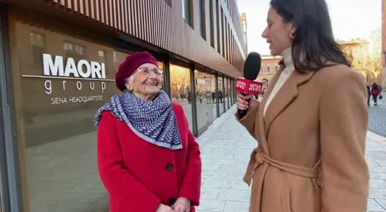[Sora 2] Siamo fuori alla sede MAORI group di Siena e la giornalista intervista una signora anziana e gli chi... - Veo 3 AI video prompt thumbnail