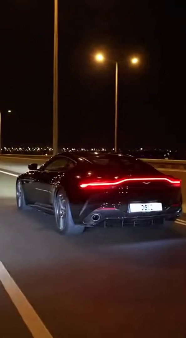 [Sora 2] Vidéo cinématographique ultra photoréaliste d’une Aston Martin DB12 noire, véhicule réel, proportion... - Veo 3 AI video prompt thumbnail