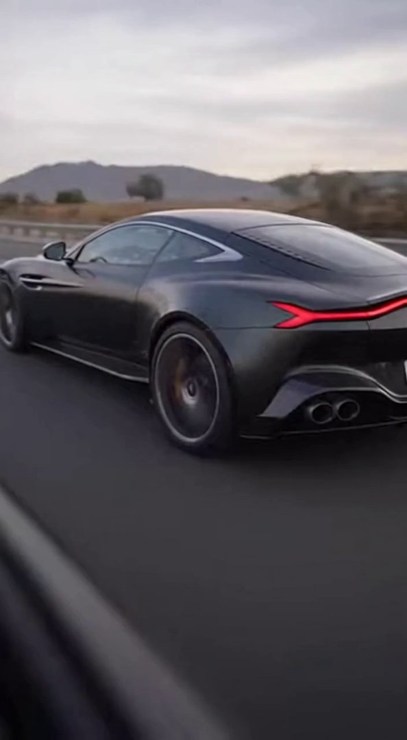 [Sora 2] Vidéo cinématographique ultra hyper réaliste d’une Aston Martin DBS / DB12 noire, véhicule réel, pro... - Veo 3 AI video prompt thumbnail