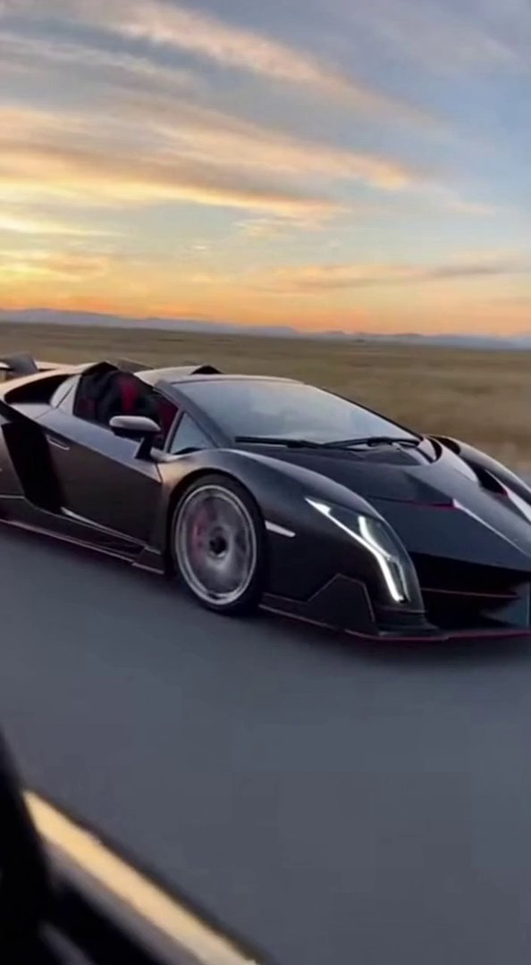 [Sora 2] Side tracking cinematic shot of a black Lamborghini Veneno Roadster driving alongside the camera car...